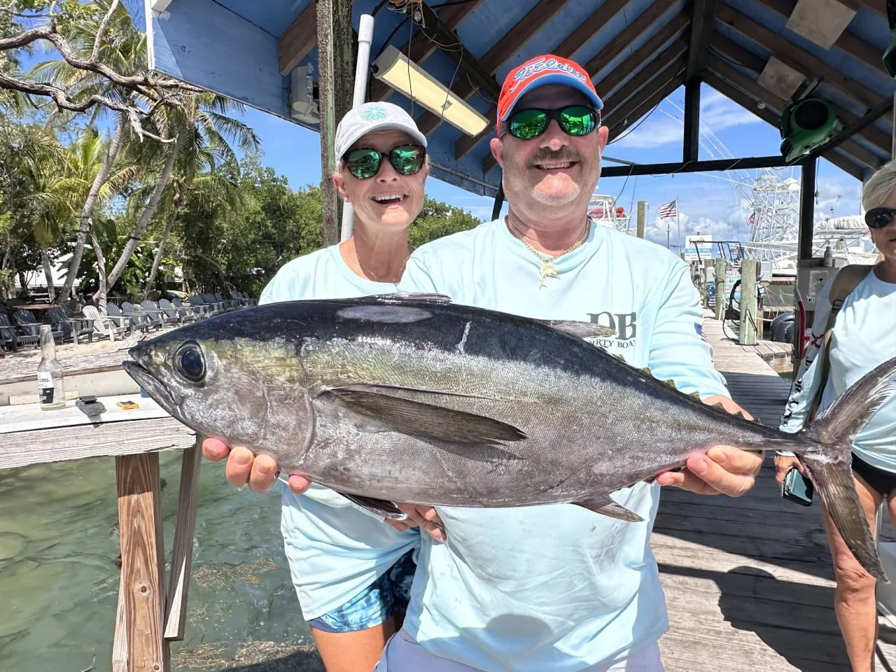 Happy DirtyBoat customers holding a big blackfin tuna caught aboard DirtyBoat 2.0 in Islamorada