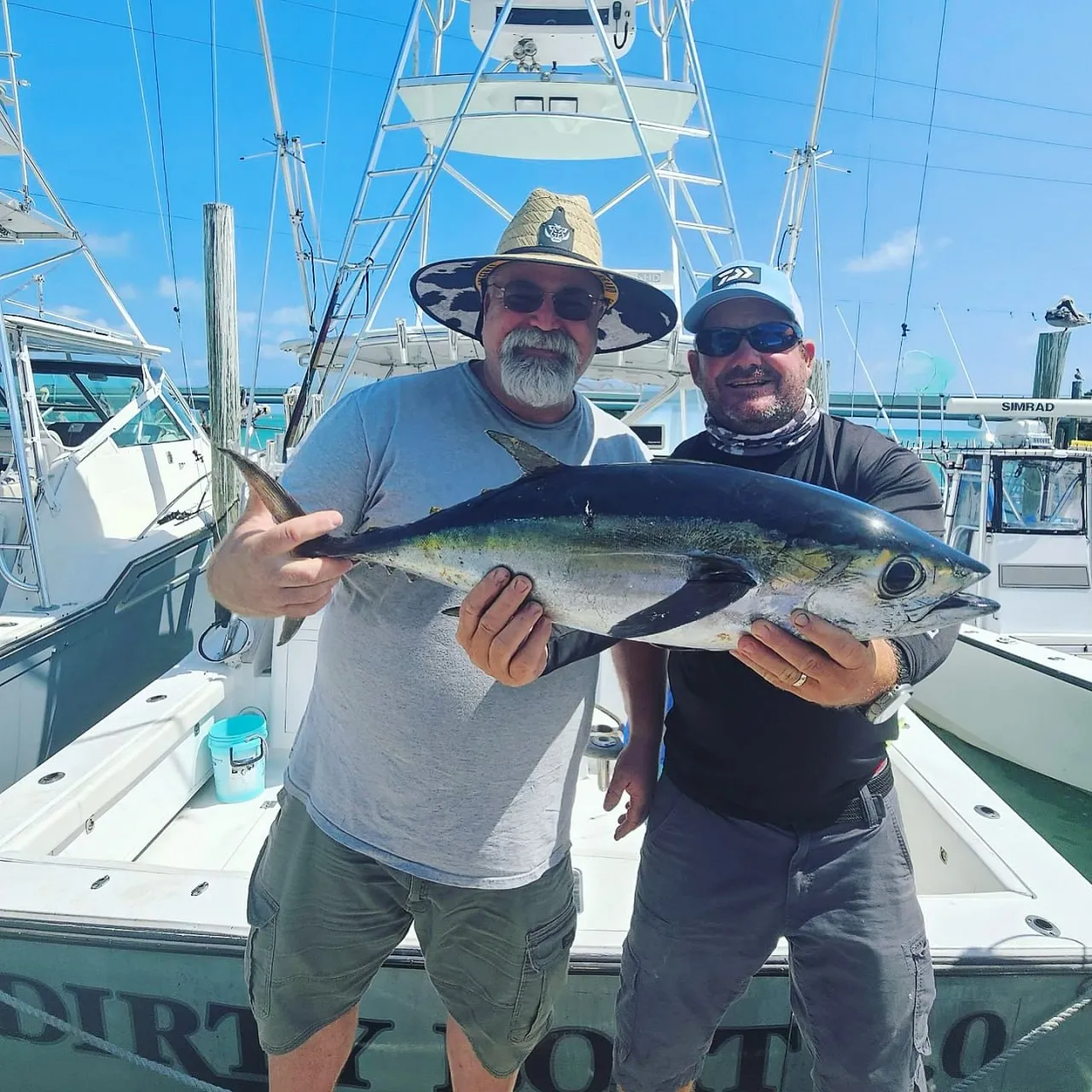 Captain Kit Carson and buddy Mike holding a big blackfin tuna at Robbie's Marina