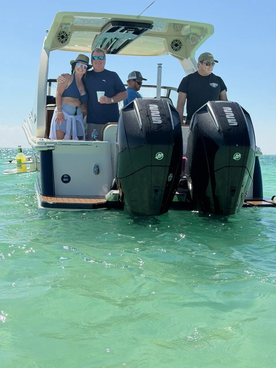 Happy guests aboard The Bougie Girl at the Islamorada sandbar with twin Mercury 225 outboards and turquoise water