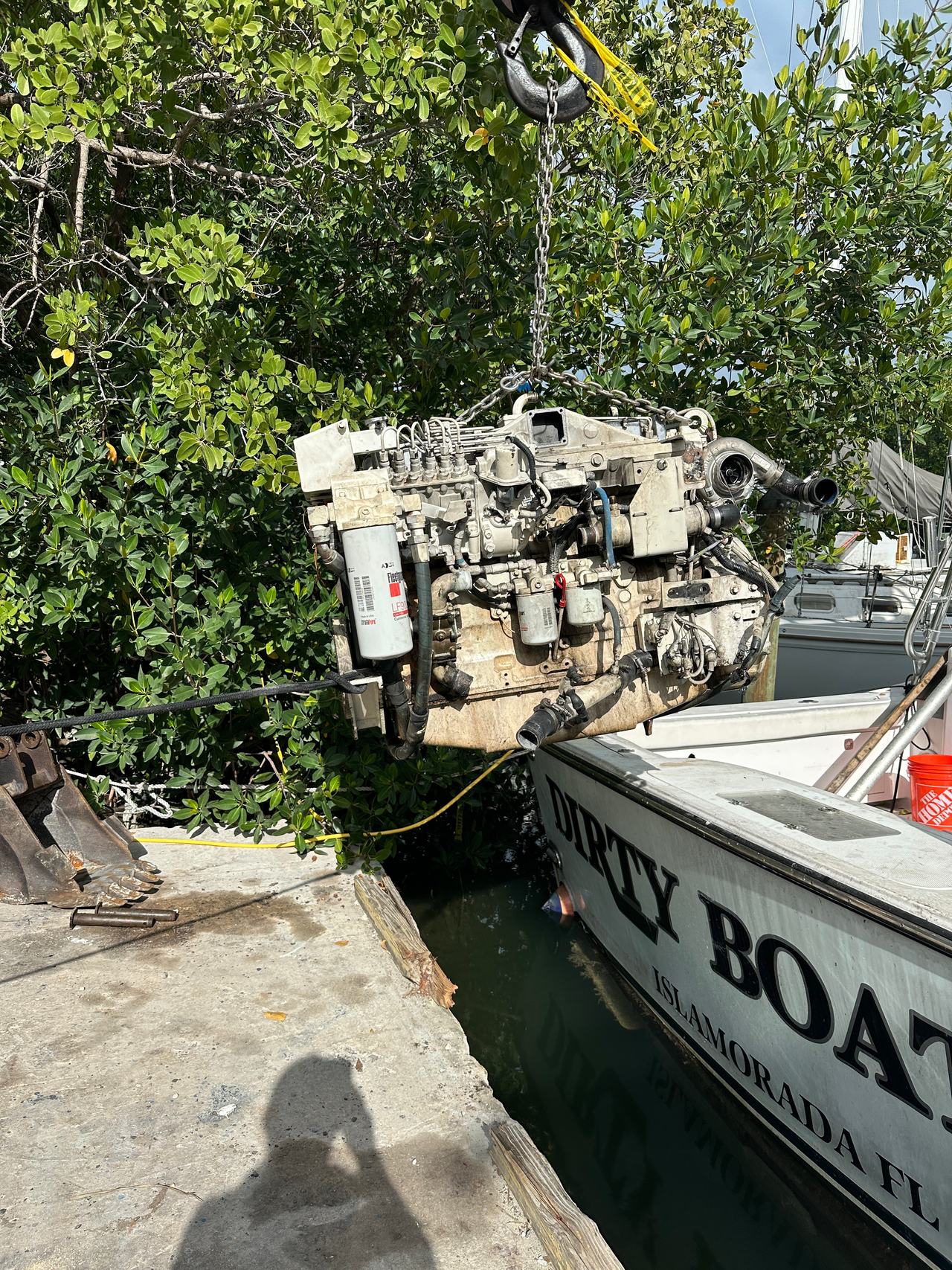 DirtyBoat 2.0's old engine being craned out dockside at Robbie's Marina in Islamorada during the repower