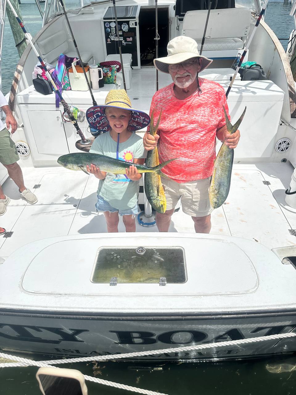 Aubreigh and Grandpa Mark with three keeper mahi on DirtyBoat